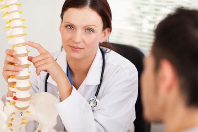 o médico mostra a osteocondrose cervical nunha maqueta